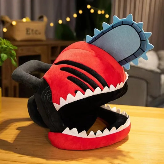 Plush toy resembling a chainsaw with red body, black accents, and blue blade on a wooden surface. Chainsaw Man Denji Premium Plush Headgear Cosplay Helmet – 35x25cm Wearable Ultra-Soft Anime Costume Mask