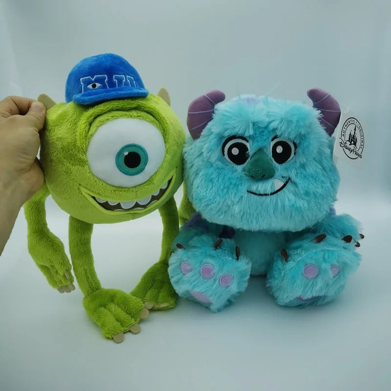 Two plush toys from Monsters Inc. on a white background, featuring Mike Wazowski in a blue cap and Sulley. Official Monsters University Sulley & Mike Premium Best Friends Plush Set by Titantoons