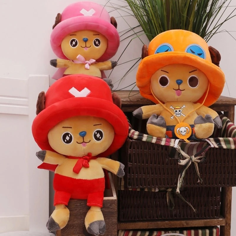Three colorful plush toys with different colored hats on a wooden shelf. One Piece: Tony Tony Chopper Luxury Character Plush