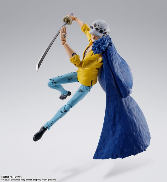 Action figure of a character in a yellow jacket and blue pants with a large blue fabric or cape, on a gray background. One Piece: Trafalgar Law (The Raid on Onigashima Ver.) Authentic S.H. Figuarts Fully Articulated Action Figure by Bandai Spirits
