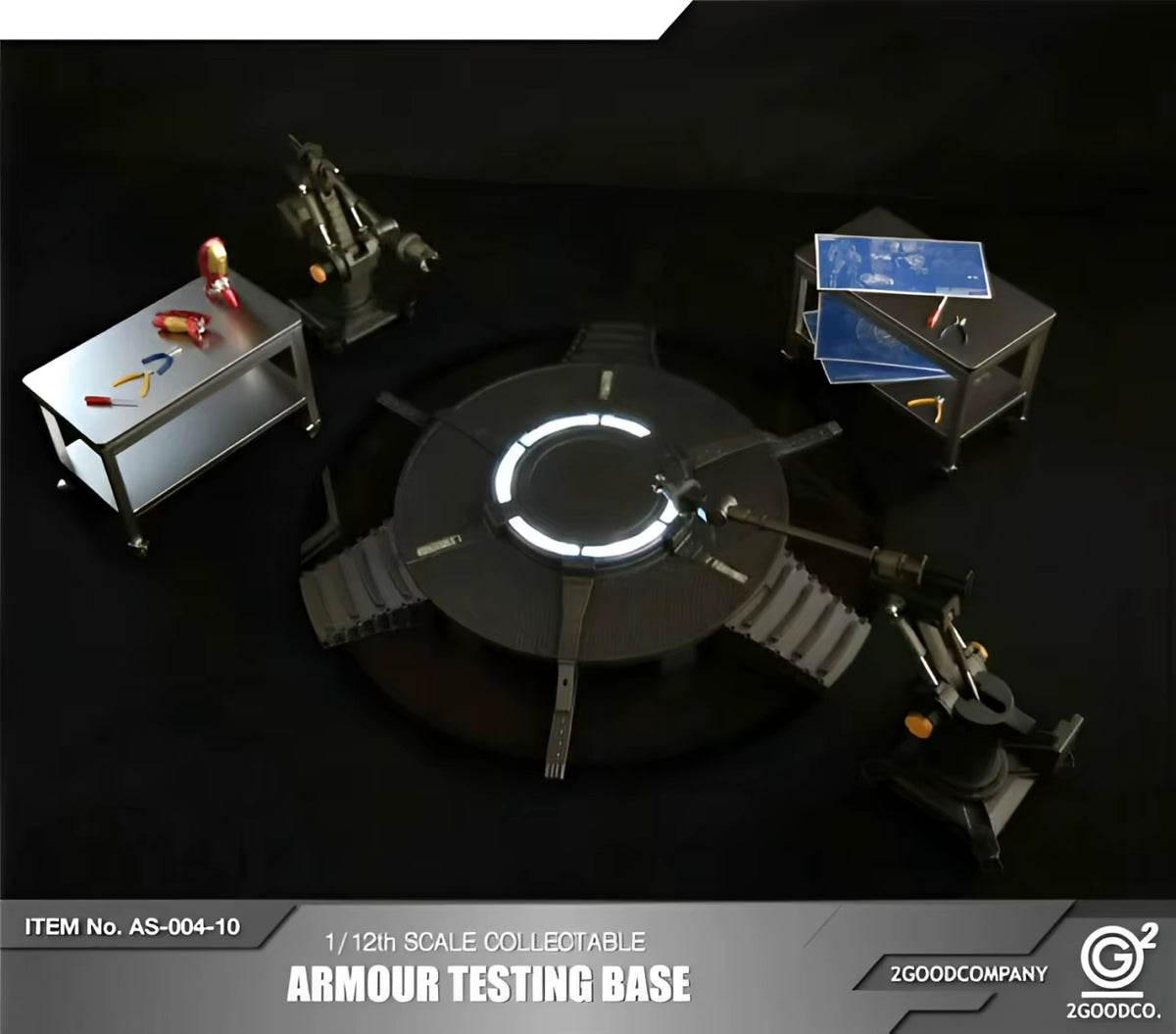 Model of an armour testing base with surrounding equipment on a dark background, featuring the 2GoodCompany logo. 2GOODCO 1/12 Scale LED Light Armor Testing Base Workshop Mechanical Diorama Set