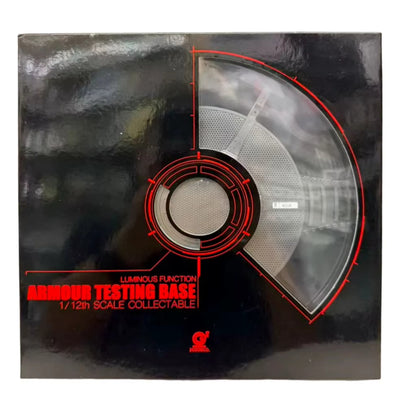Product packaging for an 'Armour Testing Base' collectible with red text and design elements. 2GOODCO 1/12 Scale LED Light Armor Testing Base Workshop Mechanical Diorama Set
