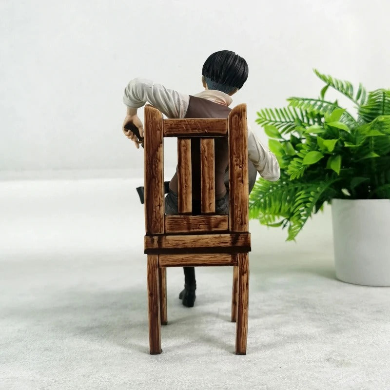 Person sitting in a wooden chair with a plant in the background Attack on Titan: Captain Levi Ackerman (Side Story Series No.1 - Tea Time) 19cm Premium Resin Statue by TITAN Studio