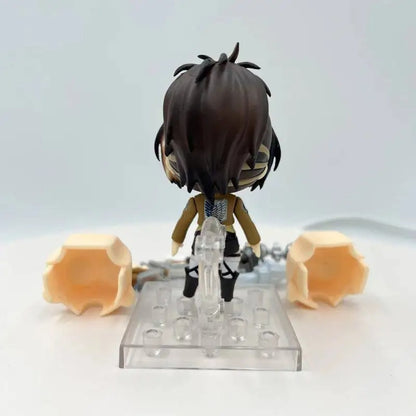 Small figurine on a clear stand with two orange objects on a white background Attack on Titan: Hange Zoë (Nendoroid No.1123) Authentic Fully Articulated Premium Chibi Figure by Good Smile Company