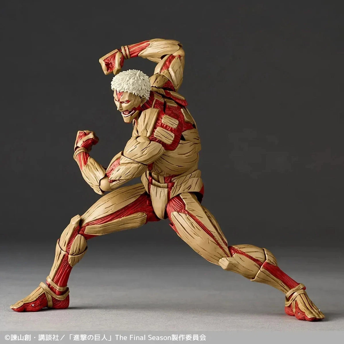 Action figure in a dynamic pose with red and beige details on a gray background Attack on Titan: Reiner Braun - The Armored Titan Amazing Yamaguchi No.042 Revoltech Action Figure by Kaiyodo
