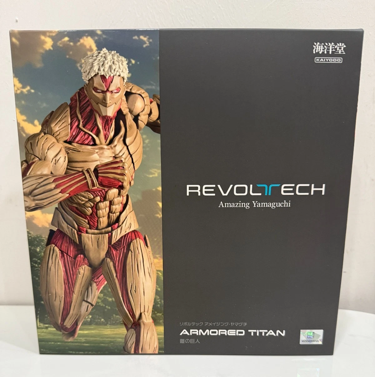Revoltech Armored Titan figure packaging with character illustration on a white background Attack on Titan: Reiner Braun - The Armored Titan Amazing Yamaguchi No.042 Revoltech Action Figure by Kaiyodo
