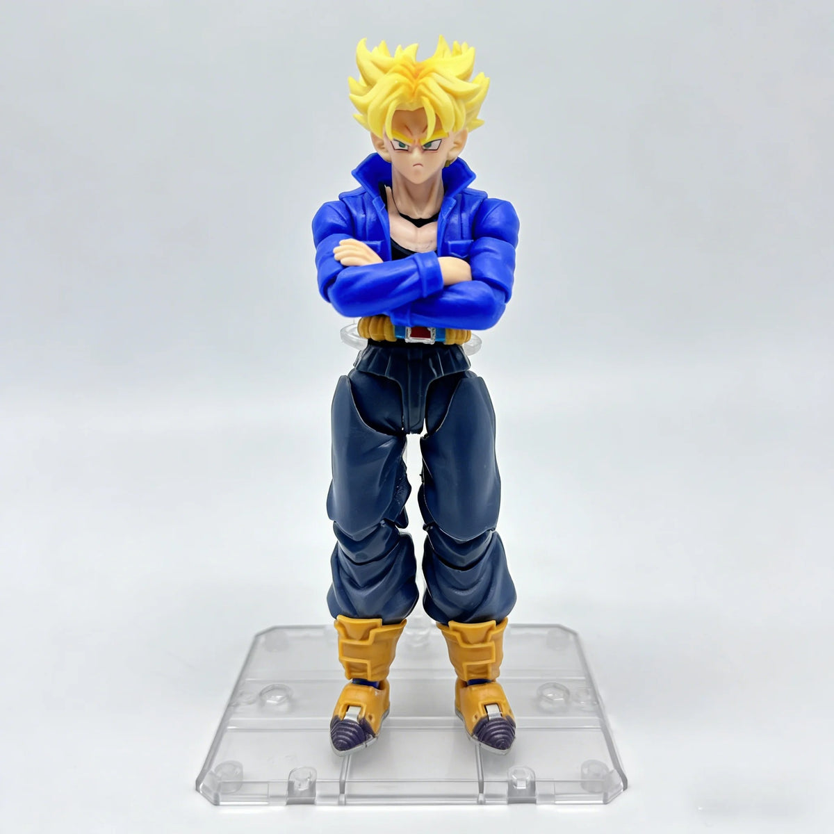 Action figure with blue outfit and yellow hair on a clear stand against a white background Bandai S.H.Figuarts Dragon Ball Z: Super Saiyan Trunks Authentic Premium Action Figure