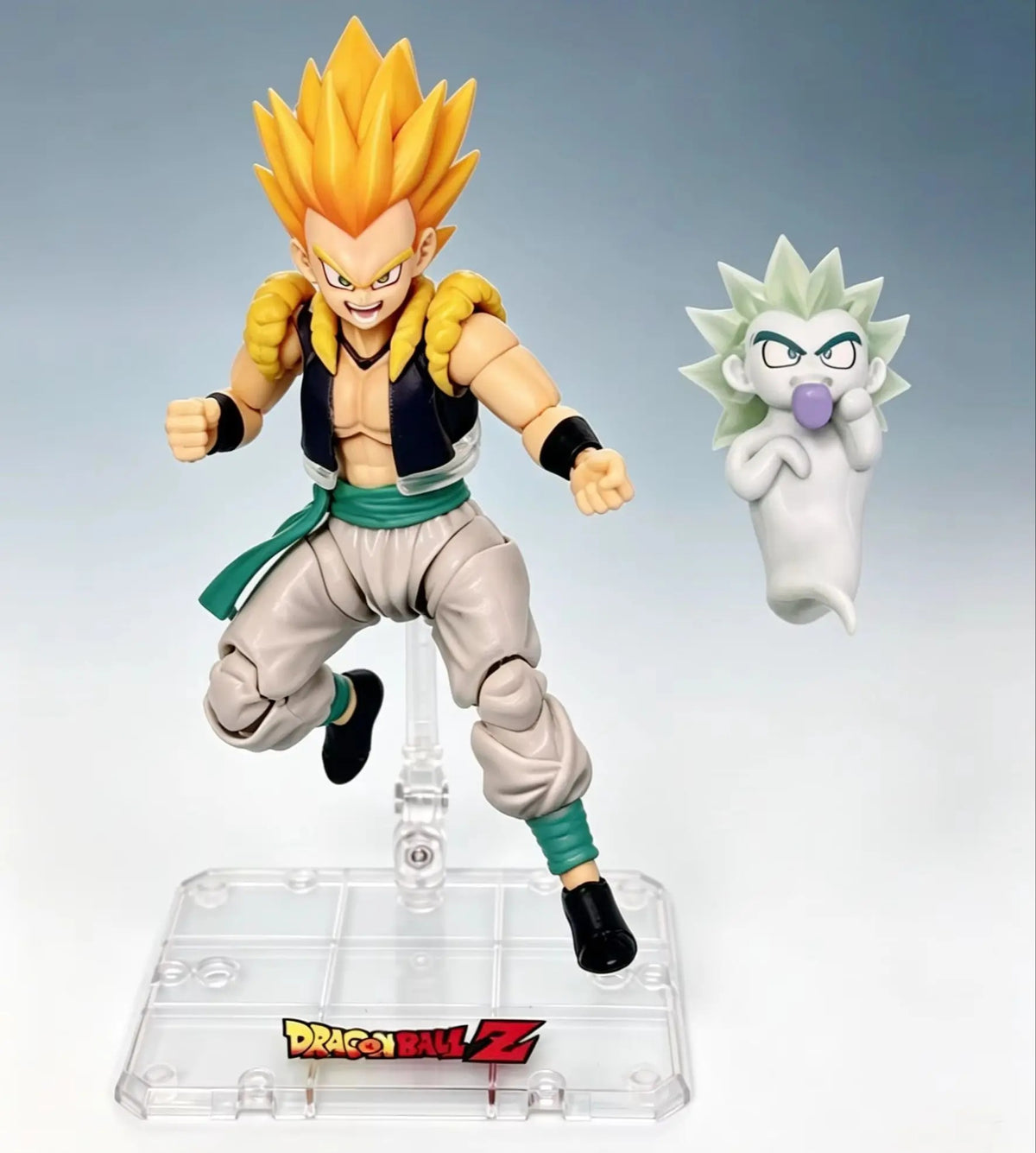 Action figure of a character from Dragon Ball Z with a small figure of another character on a clear base. Bandai S.H.Figuarts Dragon Ball Z/Super: Super Saiyan Gotenks Authentic Premium Action Figure