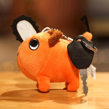 Plush keychain shaped like a cartoon character with keys attached on a wooden surface. Chainsaw Man Pochita Premium Plush Toy