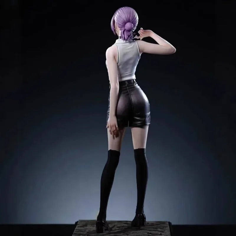 Person with purple hair styled in a bun, wearing a white top and black leather shorts against a dark background. back