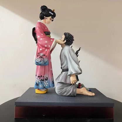 Statue of a woman in a pink kimono and a man in gray robes on a black platform.  Demon Slayer: Kimetsu no Yaiba Akaza (Hakuji) & Koyuki Authentic 10.43-Inch PVC Diorama Statue Figure – The Past Memories Edition