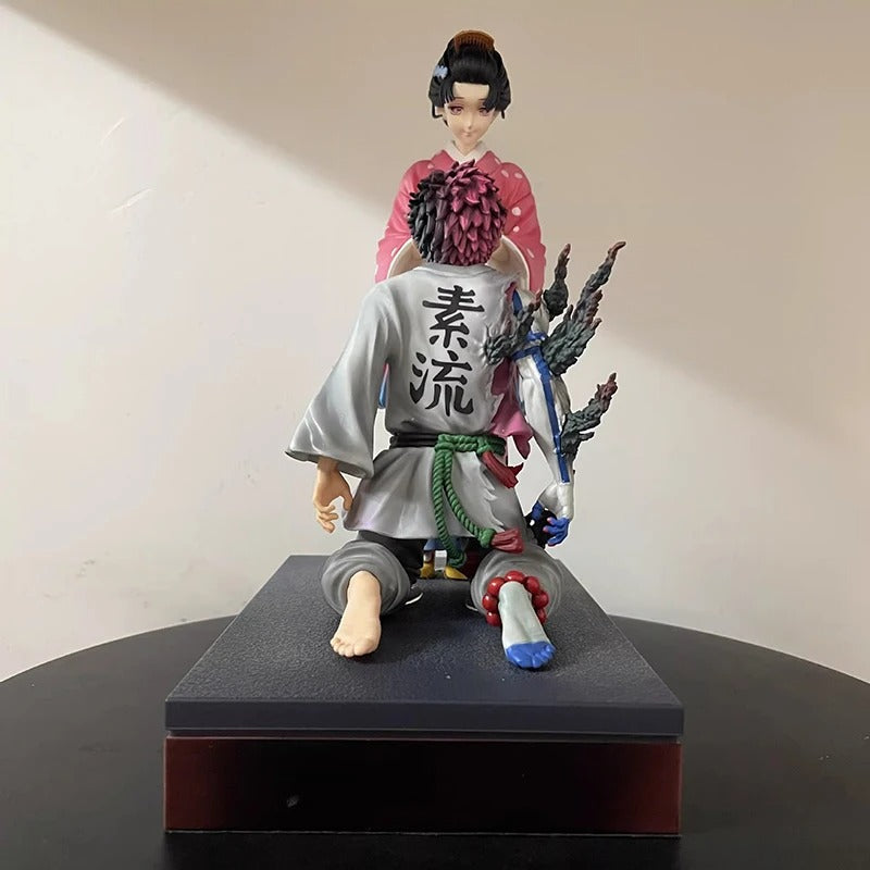 Figurine of a character in traditional attire with a weapon on a black base against a beige background Demon Slayer: Kimetsu no Yaiba Akaza (Hakuji) & Koyuki Authentic 10.43-Inch PVC Diorama Statue Figure – The Past Memories Edition