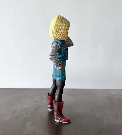 Toy figure of a character with blonde hair, blue outfit, and red boots standing on a dark surface with a white background. Dragon Ball Z: Android 18 (Lazuli) Premium 11-Inch Statue Figure – Android Saga Classic Denim Outfit Edition