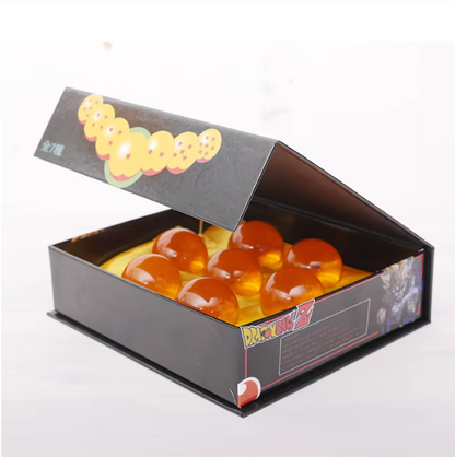 Open box containing spherical orange objects with a visible brand logo on a white background Dragon Ball Z: Premium 2.2-Inch Crystal Star Ball – High-Density Resin Prop Replica & Desk Display Edition