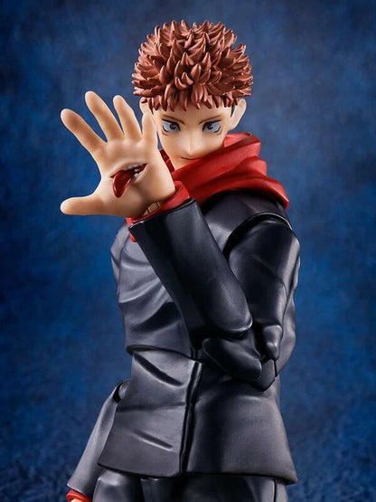 Figurine of a character with spiky hair and red scarf against a blue background Jujutsu Kaisen S.H.Figuarts Yuji Itadori Authentic 15cm Articulated Action Figure – Original Standard First Edition hand