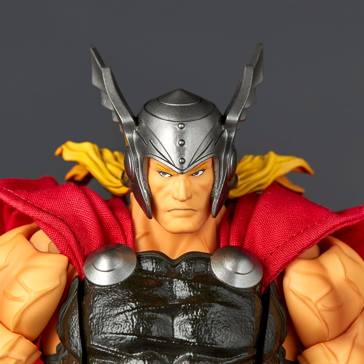 Close-up of a Thor action figure wearing a metallic silver helmet with horn-like side pieces, a red cape, and a black textured armor chest plate, against a dark gray background. Marvel Amazing Yamaguchi Revoltech NR018 Thor Authentic Action Figure