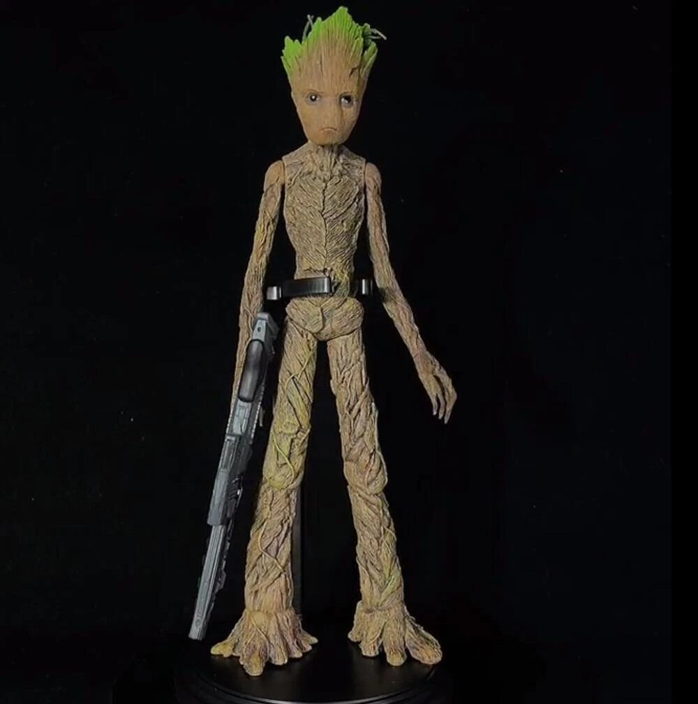 Action figure of a character with green hair and tree-like body holding a weapon on a black background Marvel Guardians of the Galaxy Groot 1/6 Scale Premium Figure by Empire Toys