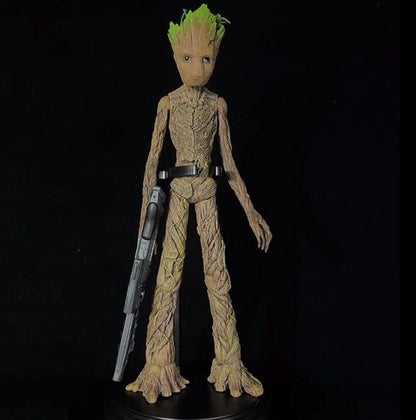 Action figure of a character with green hair and tree-like body holding a weapon on a black background Marvel Guardians of the Galaxy Groot 1/6 Scale Premium Figure by Empire Toys