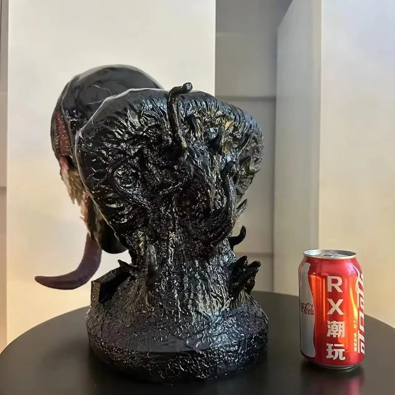 Large black textured sculpture of a creature head next to a red can on a dark surface. Marvel Universe Venom 1:1 Scale Life-Size Premium Resin Collectible Bust