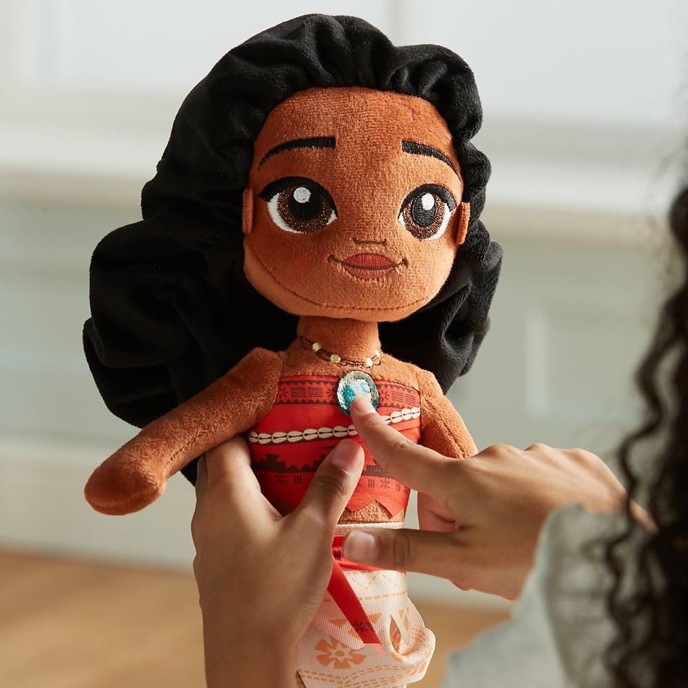 Plush toy of a character with black hair and red dress held by hands against a blurred background Official Disney Moana Wayfinder Princess – 14-Inch Premium Cotton Plush by Titantoons