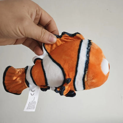 A plush toy fish with an orange body, white stripes, and black outlines, being held by a person's hand against a plain light background. Official Finding Nemo & Dory Premium Best Friends Plush by Titantoons