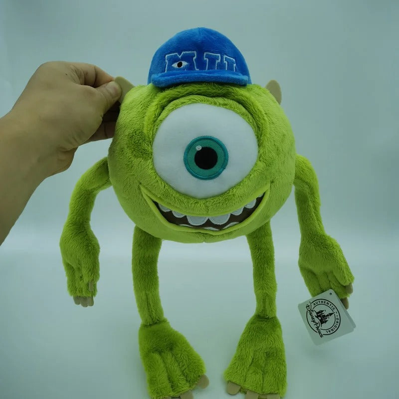 A plush toy of Mike Wazowski from Monsters Inc., featuring his signature green color, one large eye, and a blue cap with 'MILK' embroidered on it. Official Monsters University Sulley & Mike Premium Best Friends Plush Set by Titantoons face
