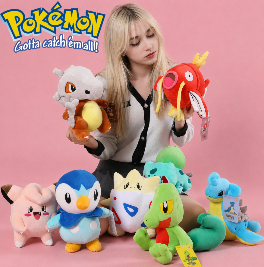 Woman holding various colorful plush toys with a pink background and 'Pokémon' branding. Official Pokémon Magikarp Premium Cotton Plush by Titantoons – 11.5-Inch