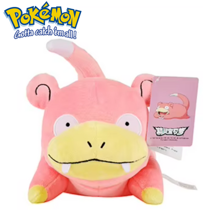 Pink and yellow plush toy with a tag, featuring the Pokémon logo. Official Pokémon Slowpoke Premium Cotton Plush by Titantoons – 12.5-Inch