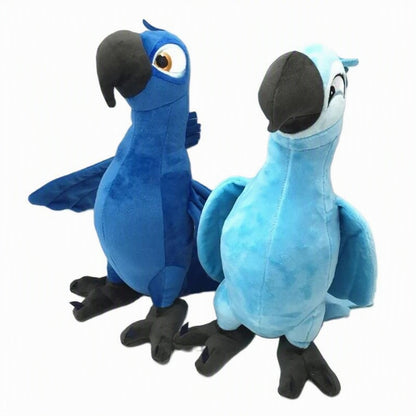 Two plush bird toys resembling Blu and Rio from Rio Grande, one in dark blue and one in light blue, both with black beaks and feet, photographed on a plain white background. Official Rio Blu & Jewel Premium Cotton Plush Collection by Titantoons