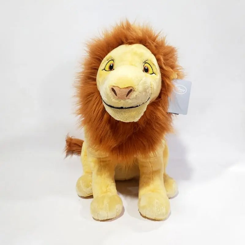 A plush lion toy with a golden-yellow face and legs, and a fluffy orange-brown mane, sitting against a plain white studio background. A small hangtag is attached to the right side of its mane. Official The Lion King Adult Simba Premium Cotton Plush by Titantoons