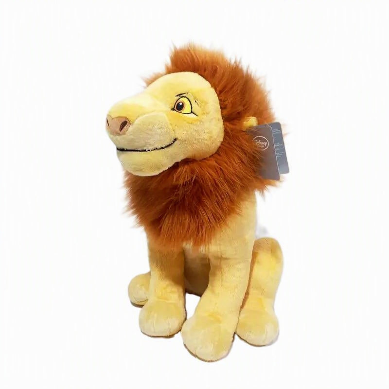 A plush lion toy with a golden-yellow body and a fluffy orange-brown mane, sitting on a plain white background. A small hangtag is attached to the side. Official The Lion King Adult Simba Premium Cotton Plush by Titantoons