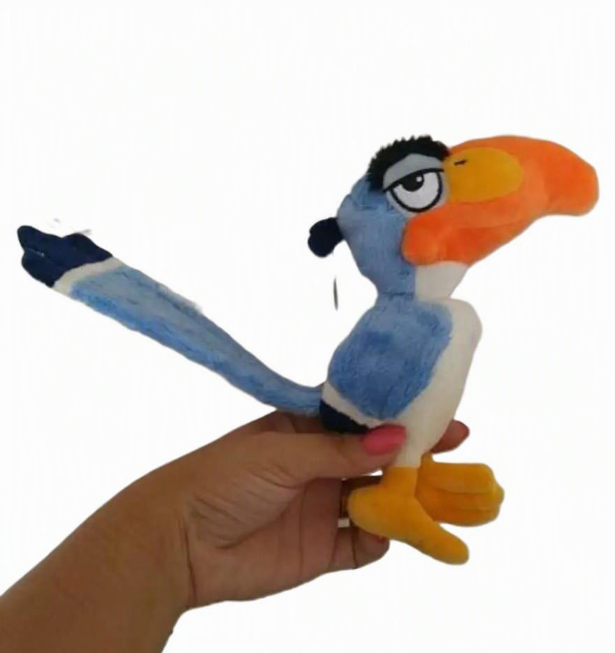 A plush toy bird with a blue body, orange beak, white underbelly, and black eye details, being held in a person's hand against a plain white background. Official The Lion King Zazu Premium Cotton Plush by Titantoons