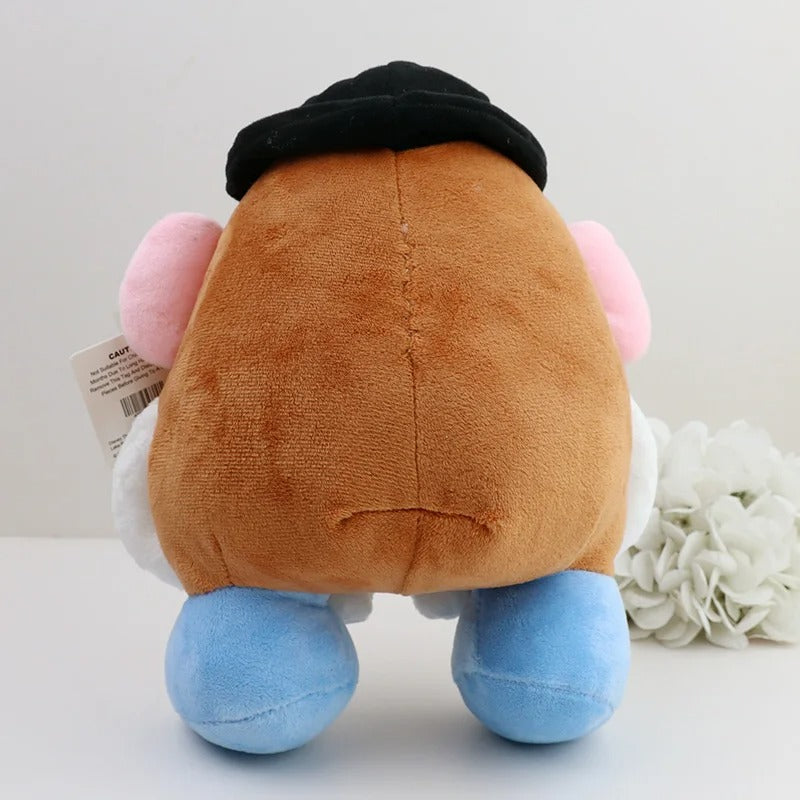 A plush toy photographed from the back, featuring a large brown body, black hat, pink ears, white side details, and blue feet, with a small product tag attached on the left and white flowers on the right against a plain light background. Official Toy Story Mr. & Mrs. Potato Head Premium Cotton Plush Collection by Titantoons