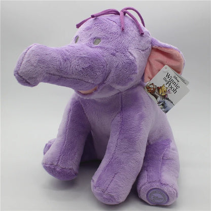 A purple plush elephant toy with pink inner ears, a purple bow on its head, and a hangtag that reads Disney Winnie the Pooh. Official Winnie the Pooh & Friends Premium Cotton Plush Collection by Titantoons – Individual Storybook Characters or Complete 9-Piece Heirloom Nursery Set