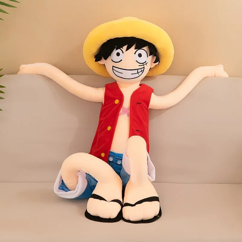 Plush toy of a character with a yellow hat and red shirt sitting on a couch. One Piece: Monkey D. Luffy Giant Luxury Anime Plush