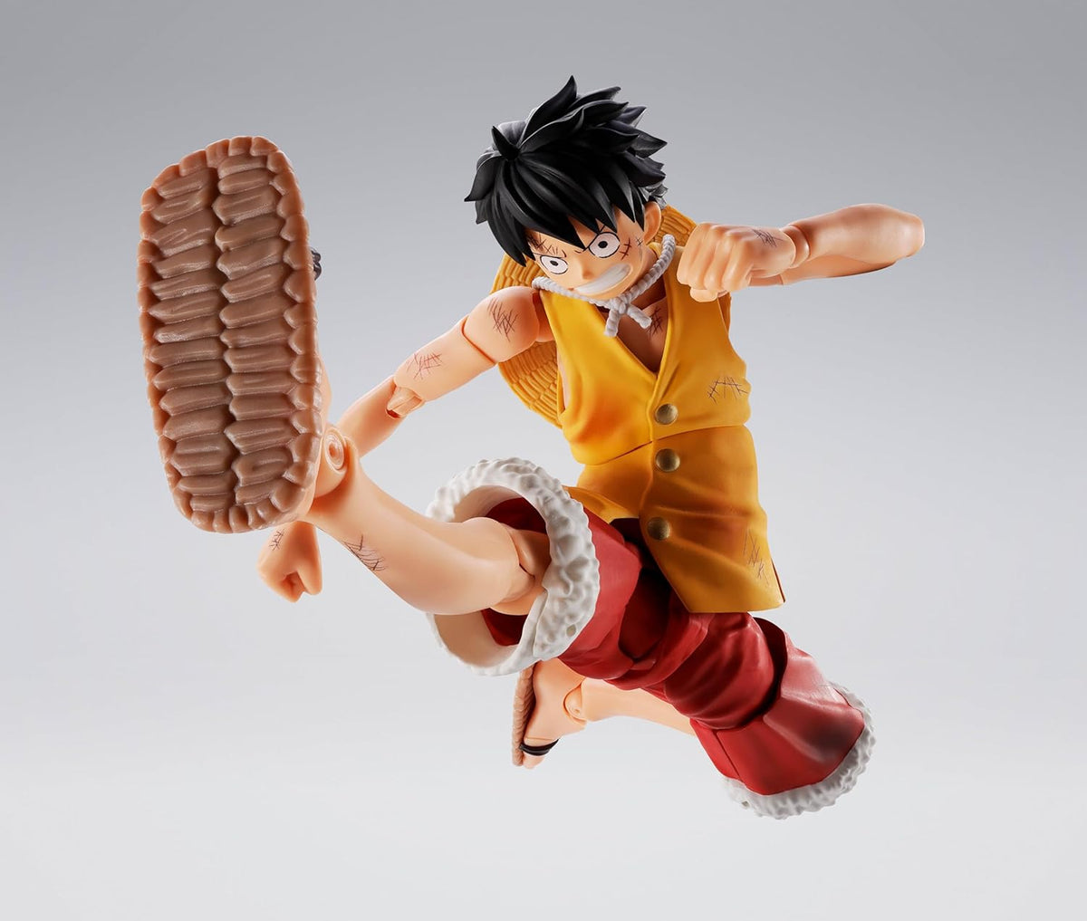 Action figure of a character in a dynamic pose on a gray background One Piece: Monkey D. Luffy (Summit War of Marineford Ver.) Authentic S.H. Figuarts Fully Articulated Action Figure by Bandai Spirits