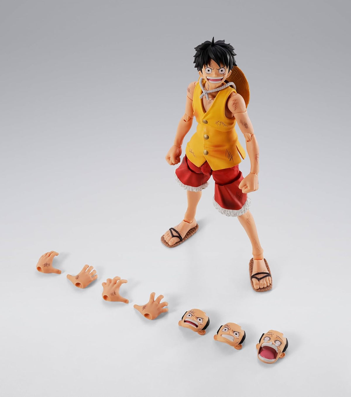 Action figure with interchangeable face parts on a gray background One Piece: Monkey D. Luffy (Summit War of Marineford Ver.) Authentic S.H. Figuarts Fully Articulated Action Figure by Bandai Spirits