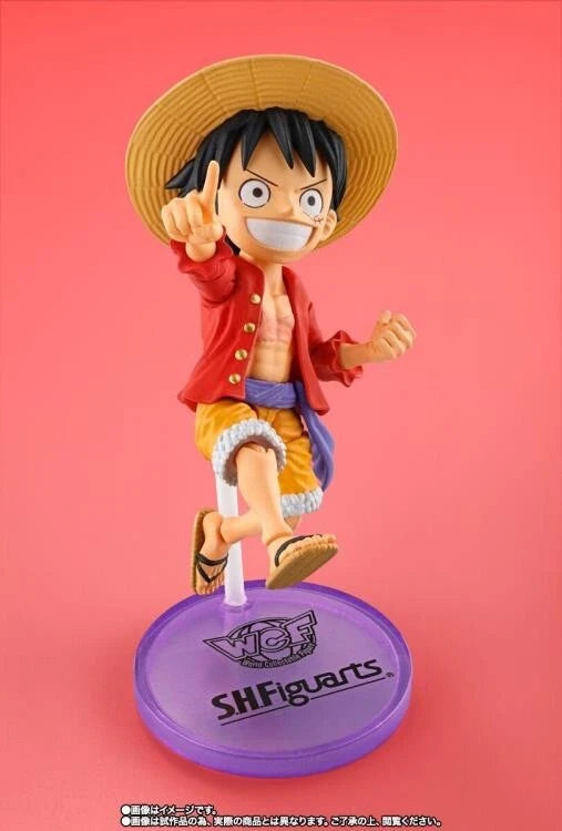 Figurine of a character from a popular anime series on a pink background One Piece: Monkey D. Luffy (WCF x S.H. Figuarts Ver.) Authentic Fully Articulated Chibi Action Figure by Bandai Spirits