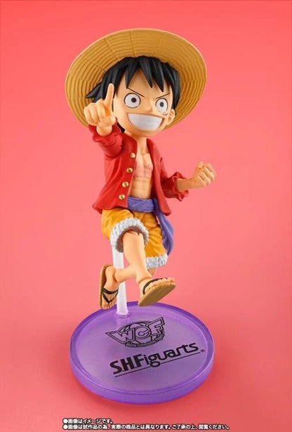 Figurine of a character from a popular anime series on a pink background One Piece: Monkey D. Luffy (WCF x S.H. Figuarts Ver.) Authentic Fully Articulated Chibi Action Figure by Bandai Spirits