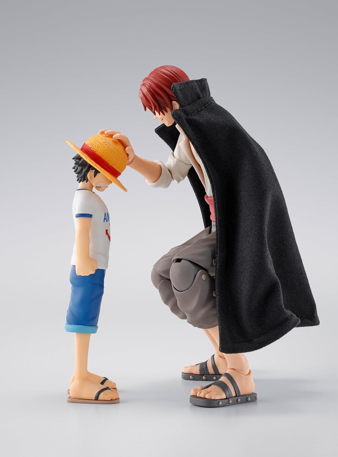 Two figurines in a dynamic pose on a plain background One Piece: Shanks & Monkey D. Luffy (Childhood Ver.) Authentic S.H. Figuarts Fully Articulated Twin-Pack Action Figure Set by Bandai Spirits