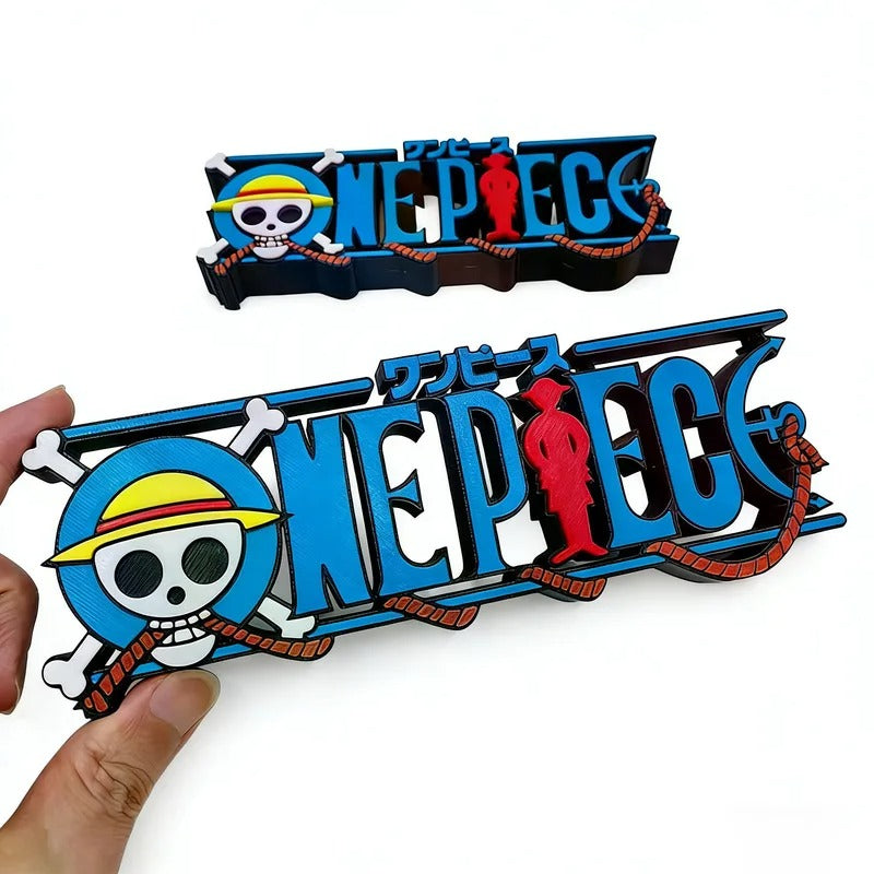 Two 'One Piece' logo magnets held by a hand on a white background One Piece: Straw Hat Pirates Jolly Roger 3D Printed Standing Logo Sign – Premium 15cm Desktop Display & Media Shelf Anchor