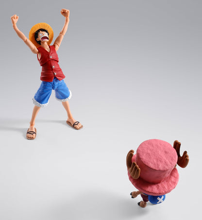 Two action figures, one standing with arms raised and the other sitting on the ground, on a gray background. One Piece: Tony Tony Chopper (Drum Island Ver.) Authentic S.H. Figuarts Fully Articulated Action Figure by Bandai Spirits