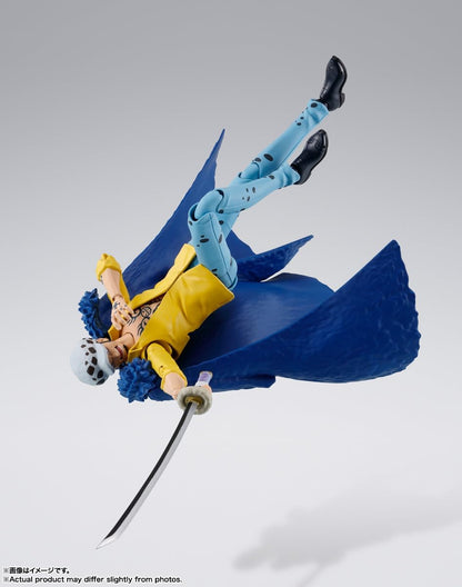 Action figure in dynamic pose with blue cape and yellow outfit on gray background One Piece: Trafalgar Law (The Raid on Onigashima Ver.) Authentic S.H. Figuarts Fully Articulated Action Figure by Bandai Spirits 4
