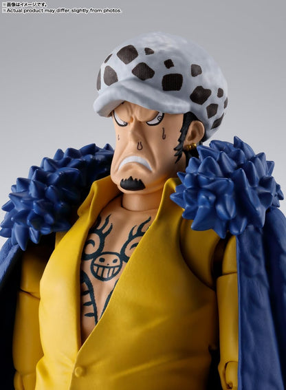 Action figure with a yellow jacket and blue scarf on a gray background One Piece: Trafalgar Law (The Raid on Onigashima Ver.) Authentic S.H. Figuarts Fully Articulated Action Figure by Bandai Spirits