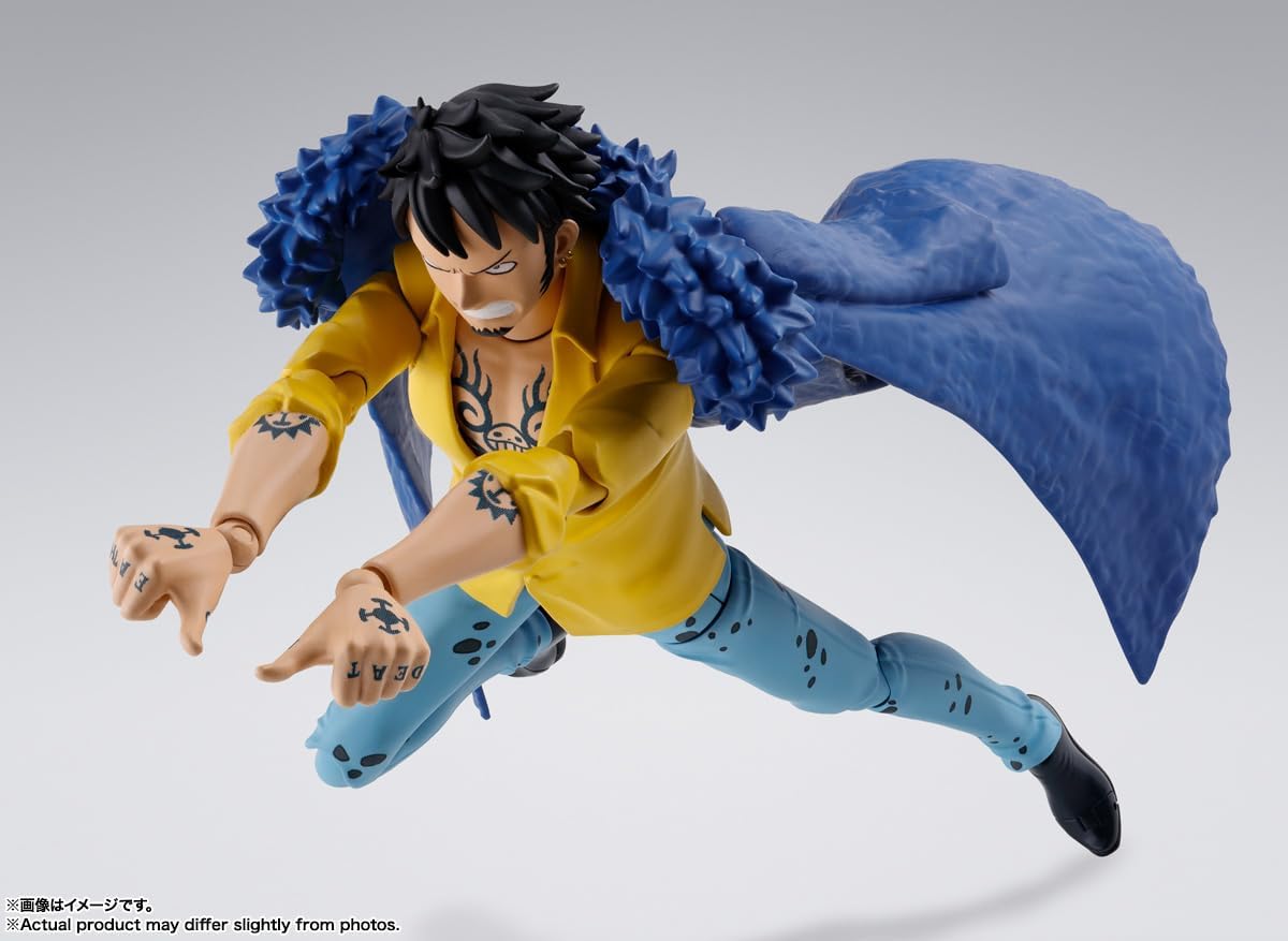 Action figure of a character in a yellow shirt and blue pants with a large blue creature on a gray background One Piece: Trafalgar Law (The Raid on Onigashima Ver.) Authentic S.H. Figuarts Fully Articulated Action Figure by Bandai Spirits