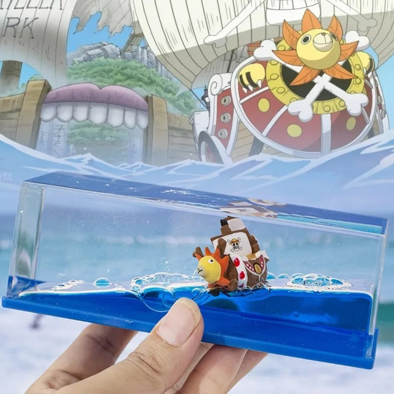 Toy ship with characters in a transparent box held by a hand, with a colorful background One Piece: Unsinkable Ship Liquid Drift Bottle – Thousand Sunny & Going Merry Premium Acrylic Desktop Motion Decor with Separate USB LED Illuminating Base