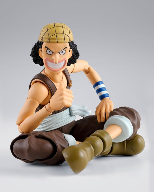 Action figure of a character from an anime sitting on a gray background One Piece: Usopp (Romance Dawn Ver.) Authentic S.H. Figuarts Fully Articulated Action Figure by Bandai Spirits