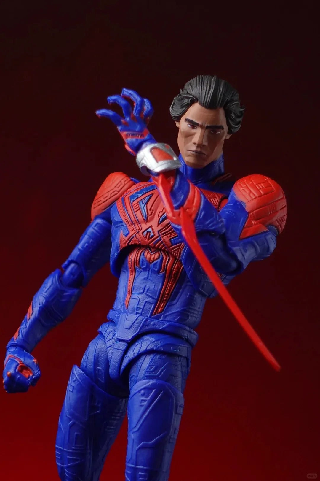 Superhero action figure in blue and red costume with red sword on dark red background Spider-Man 2099 (Miguel O'Hara) Across The Spider-Verse 1/12 Scale Action Figure by CT Toys