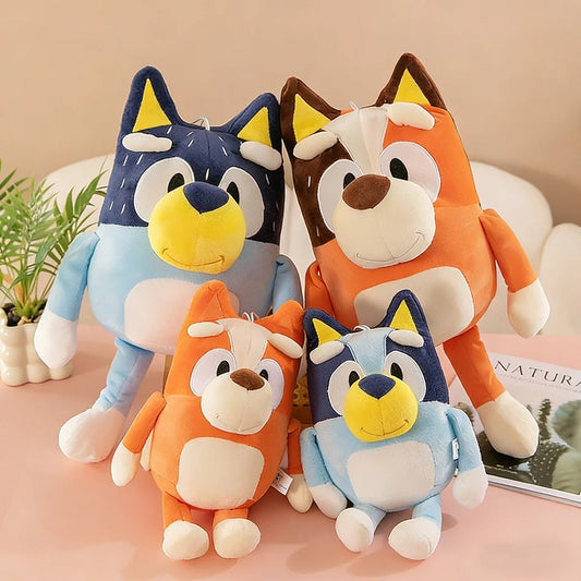 Four cartoon-style plush toys resembling foxes on a pink surface with a plant and magazine in the background. Sweet Little Bingo Cuddle Friend – 14-Inch Premium Cotton Plush by Titantoons 