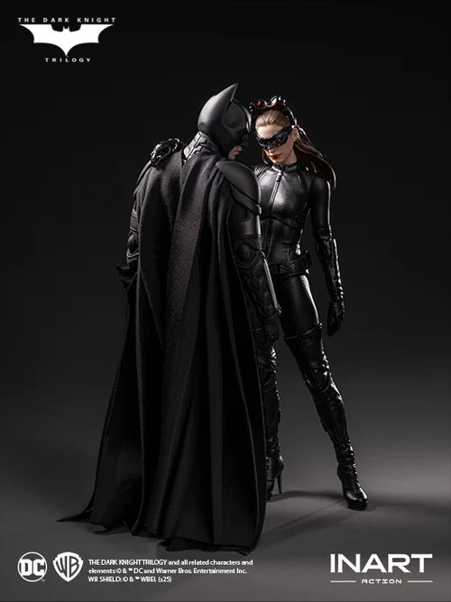 Two superhero figures, one in a cape and the other in a suit, standing close together on a dark background with logos at the top and bottom.